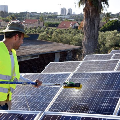 worker washing solar panels